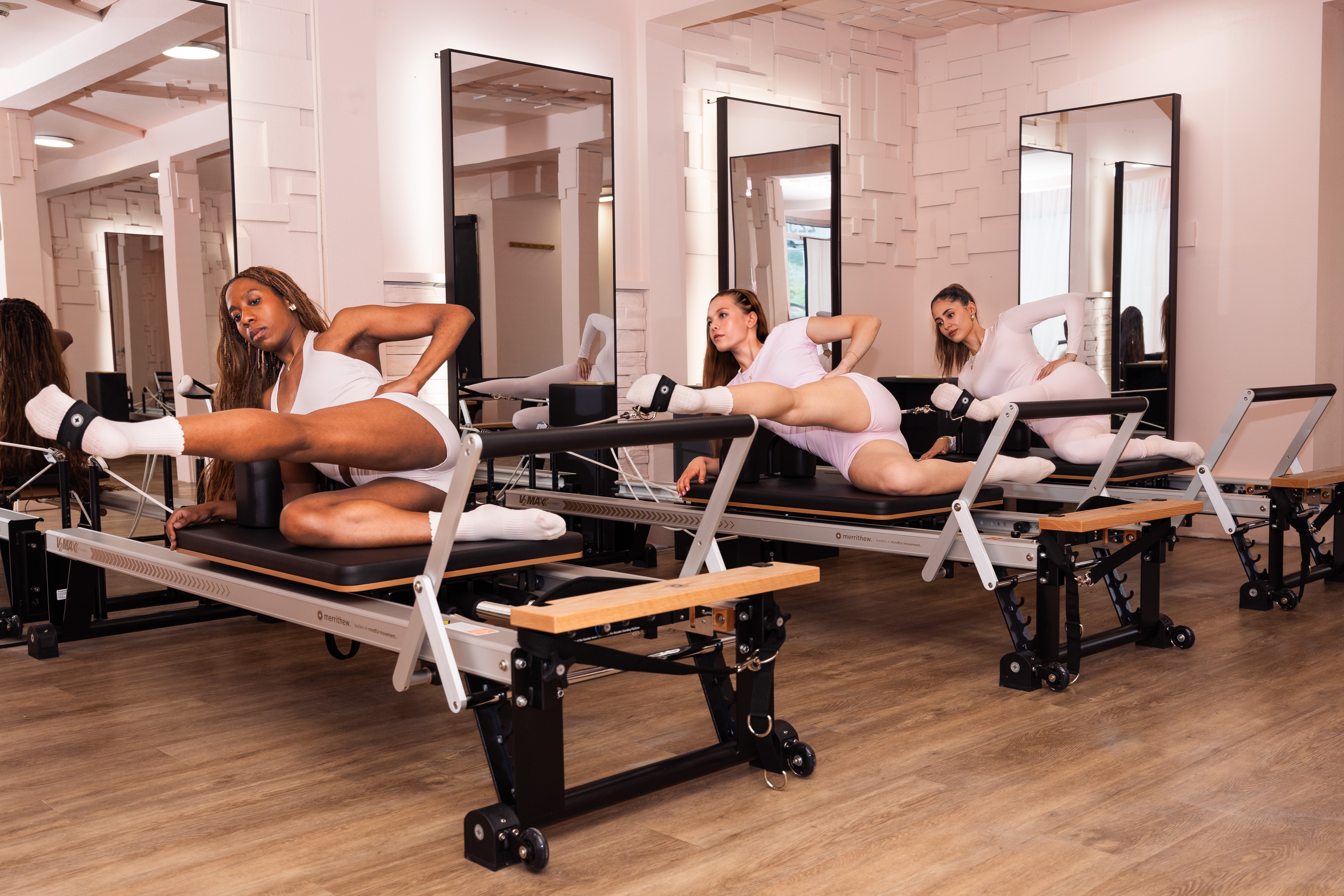 Trois participantes pratiquant le Pilates Reformer au Club Rosé
